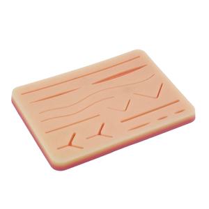 Medical skin suture practice silicone pad used for surgical training, showing realistic human skin texture with multiple pre-cut wounds for practicing suturing techniques
